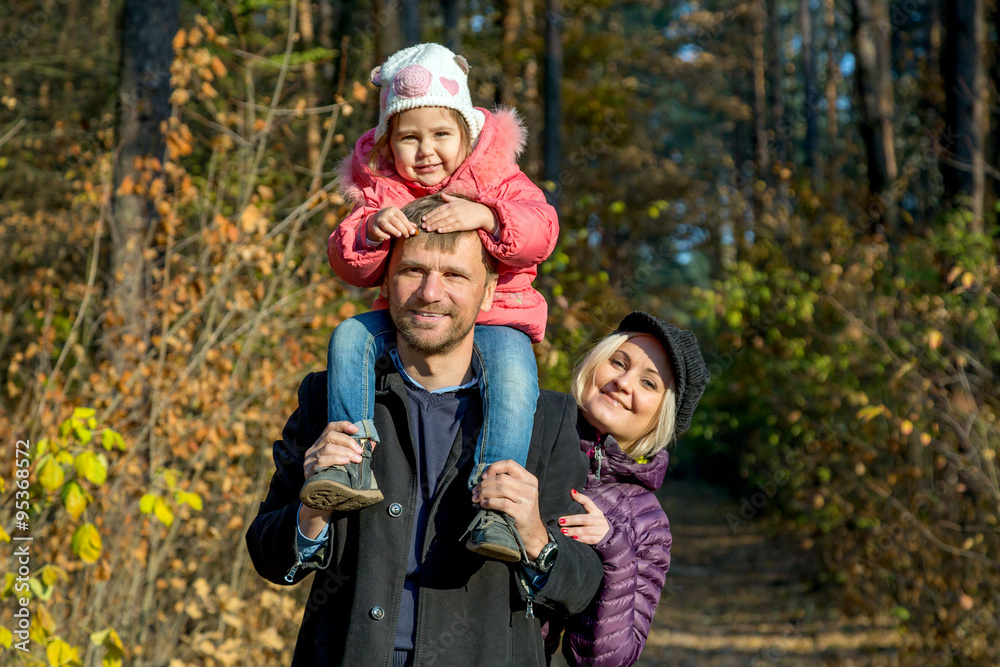 Happy Family on the Walk in Autumnal Forest Father Mother Little Baby Daughter Together on Weekend Walk on Autumnal Colors Forest Sunny Day Smiling Faces Child Sitting on Daddy Shoulders Happy Family on the Walk in Autumnal Forest Father Mother Little Baby Daughter Together on Weekend Walk on Autumnal Colors Forest Sunny Day Smiling Faces Child Sitting on Daddy Shoulders