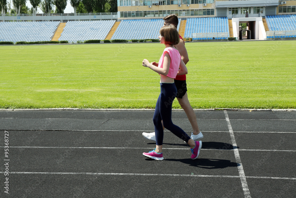 Fototapeta premium Young people jogging on stadium