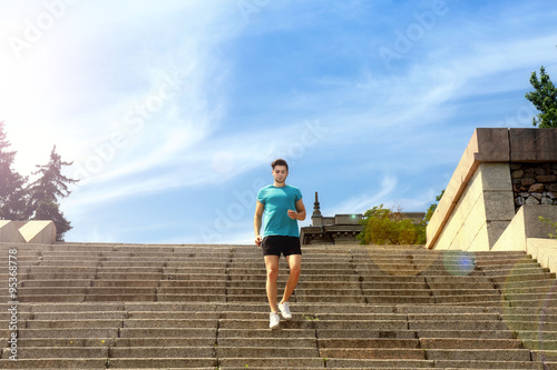 Young man jogging at stairs outdoors