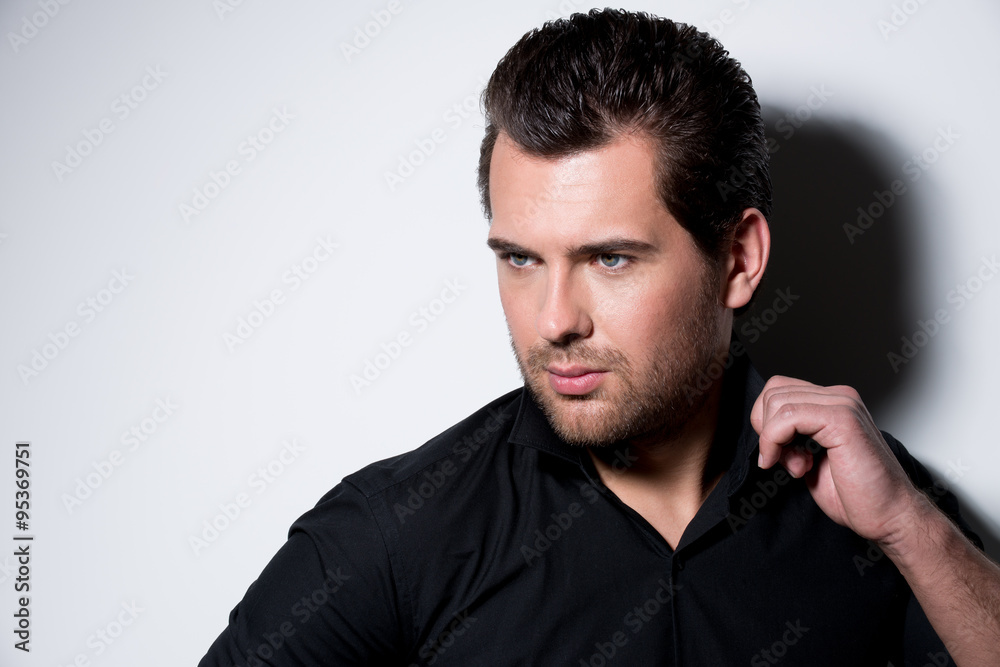 Fashion portrait of young man in black shirt .