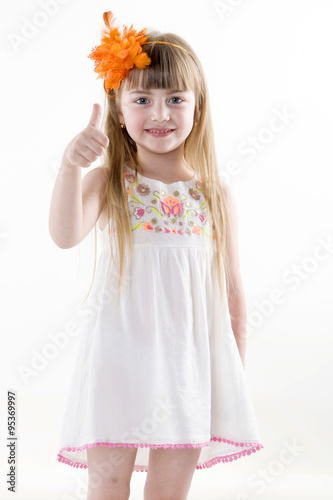 the young girl on the white dress  posing and pointing hand for the camera showing funny faces isolated on the white background