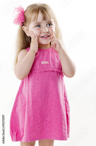 little girl in a pink dress posing for the camera showing funny faces