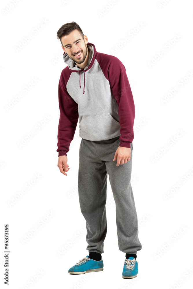 Young man in sporty hoodie spontaneously laughing at camera. Full body length portrait isolated over white studio background. Stock Photo Adobe Stock