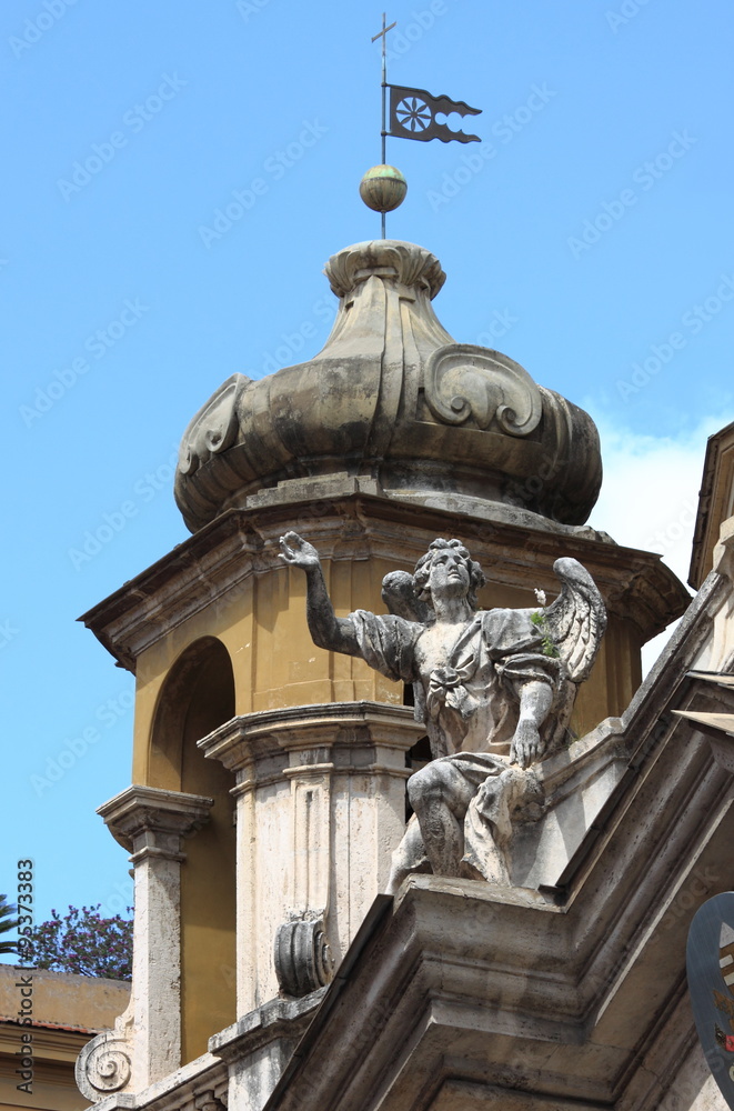 Angel statue on top of baroque church in Rome, Italy