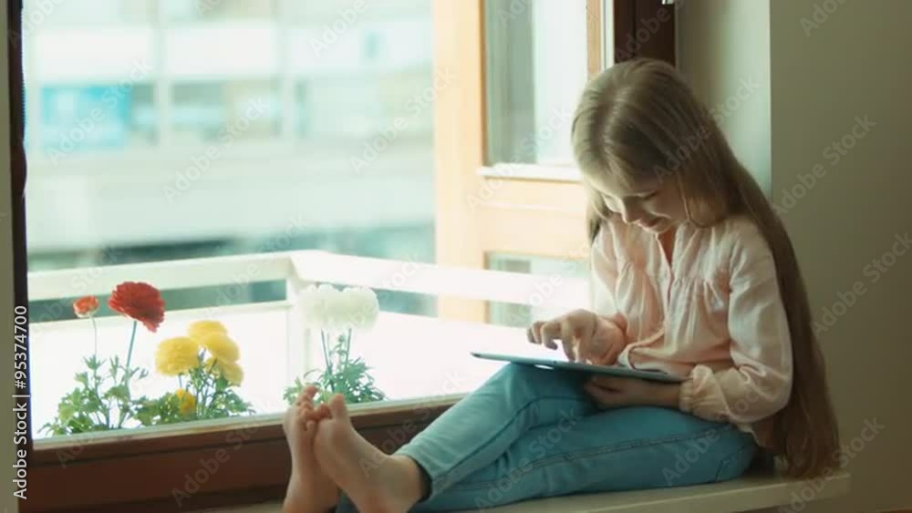 Child surprised and covers her mouth Looking at camera. Blond little girl using tablet pc and sitting on the window sill. Child smiling and laughing Child surprised and covers her mouth Looking at camera. Blond little girl using tablet pc and sitting on the window sill. Child smiling and laughing