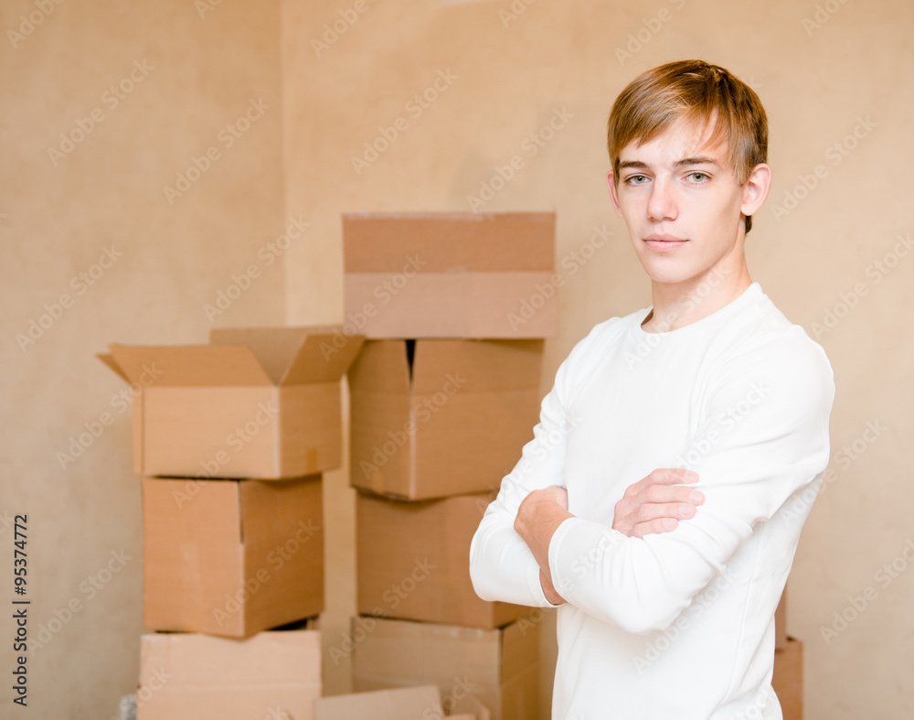 serious young boy standing on a background of cardboard serious young boy standing on a background of cardboard