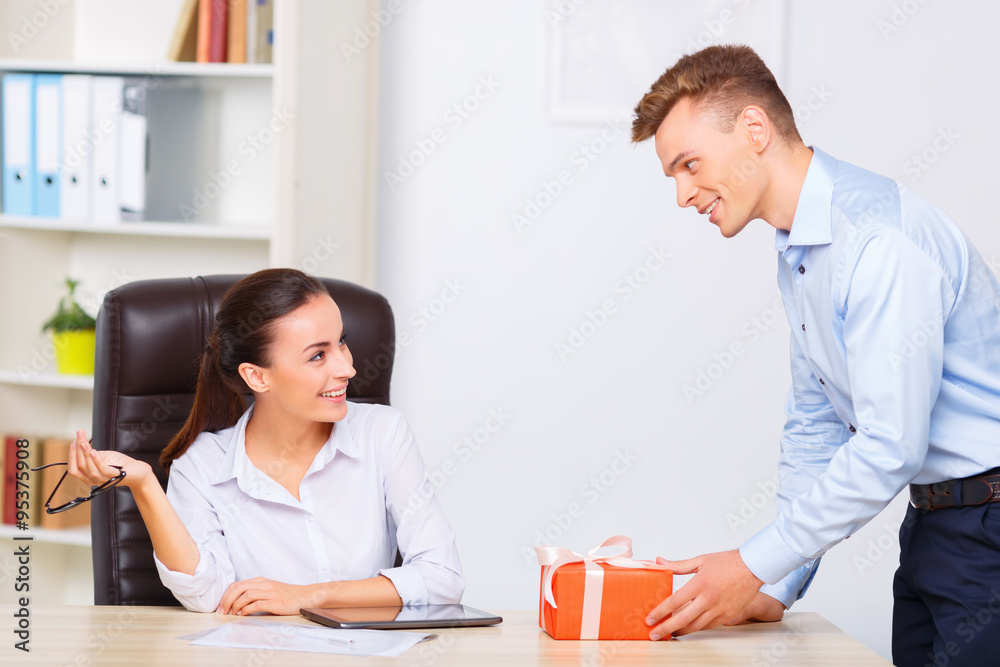 Officeman gives present to his female partner. Officeman gives present to his female partner.