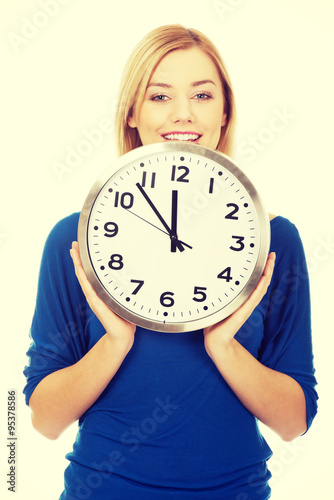Young woman holding a clock.