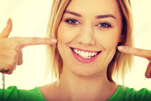 Woman pointing at teeth.