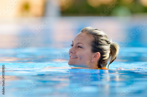 young woman swimming in the pool on a warm summer day