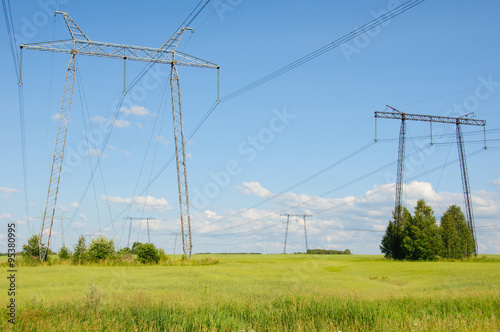 Power lines in the countryside against blue sky