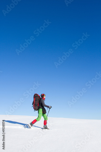 Winter hiking in the mountains on snowshoes with a backpack and tent.