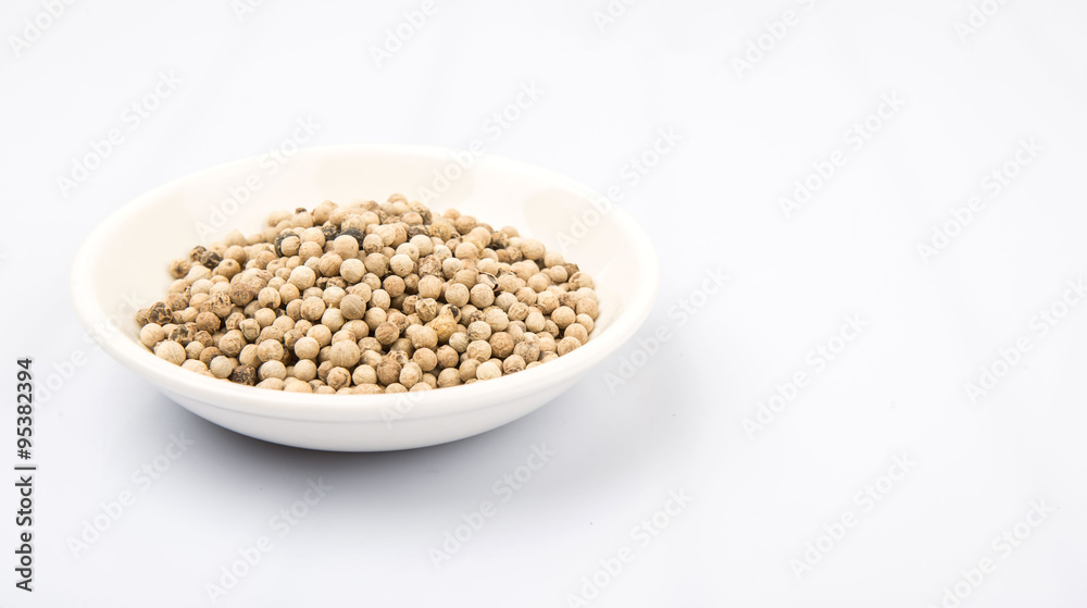 White peppercorn in white bowl over white background White peppercorn in white bowl over white background
