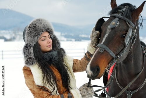 beautiful brunette woman portrait with horse in winter
