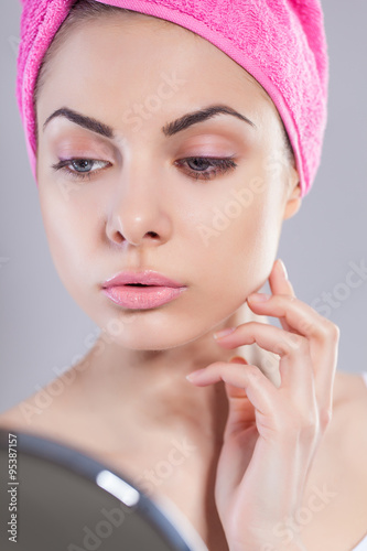 Portrait of young woman with perfect health skin of face and bath towel on head