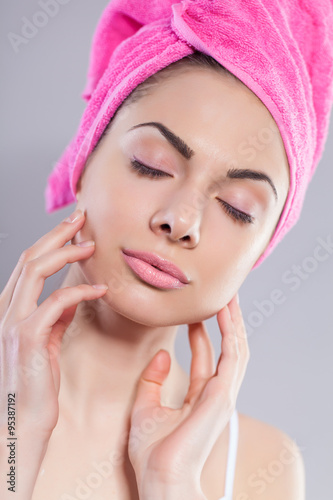 Portrait of young woman with perfect health skin of face and bath towel on head
