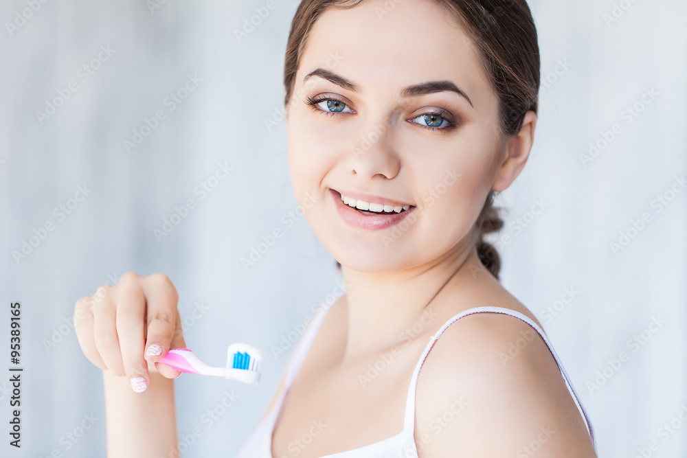 Beautiful smiling woman holding a toothbrush and toothpaste, fresh studio portrait Beautiful smiling woman holding a toothbrush and toothpaste, fresh studio portrait