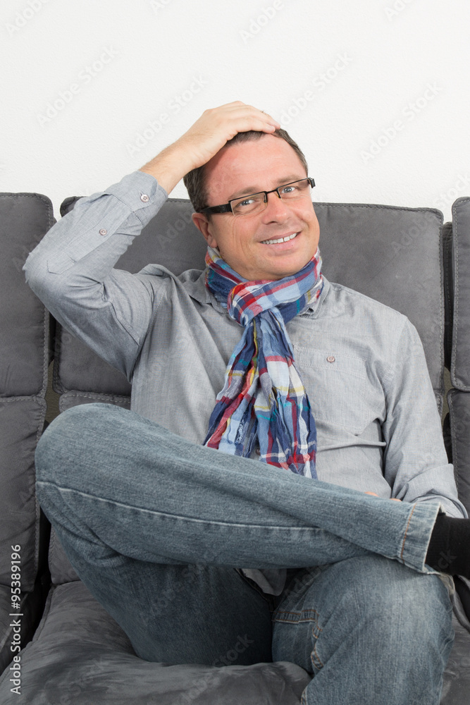 Man sitting on his couch at home Man sitting on his couch at home