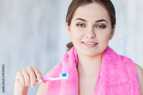 Beautiful smiling woman holding a toothbrush and toothpaste  fresh studio portrait