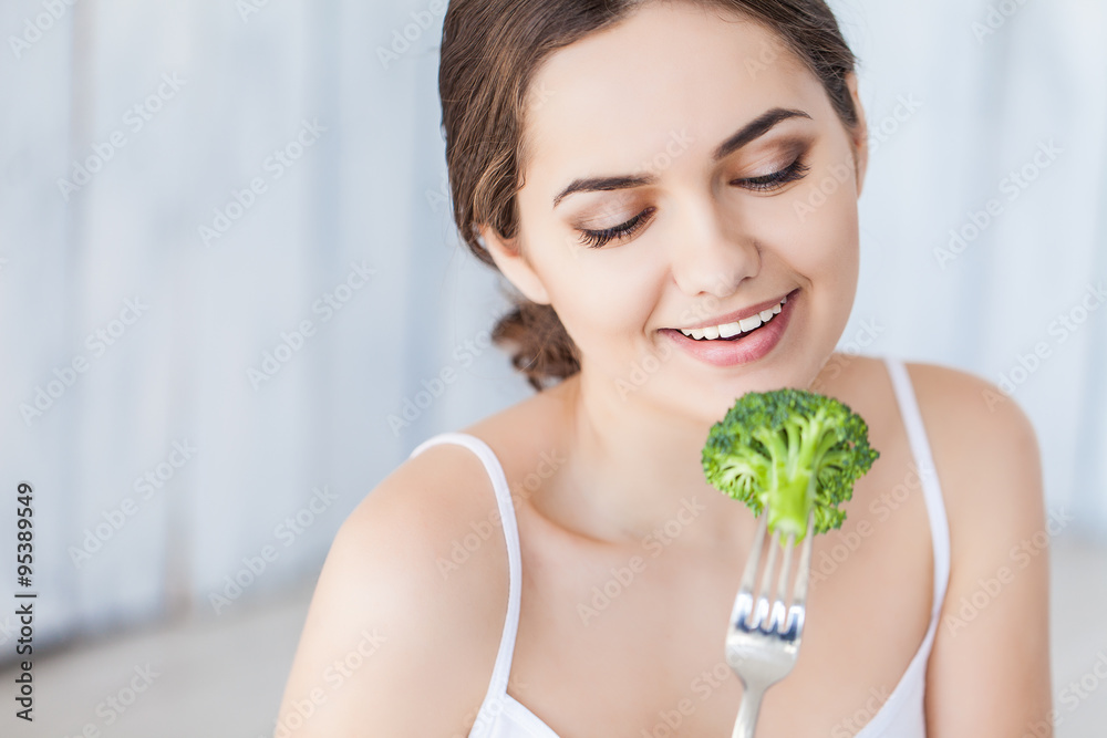 Portrait of happy smiling young beautiful woman eating broccoli Portrait of happy smiling young beautiful woman eating broccoli
