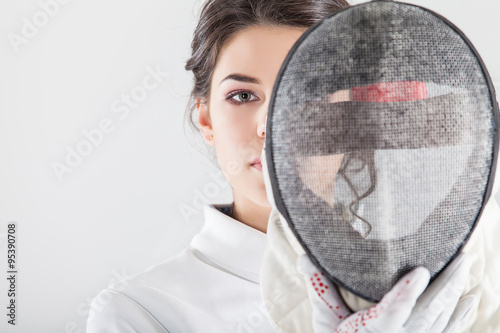 Fotografija Portrait of woman wearing white fencing costume practicing with the sword
