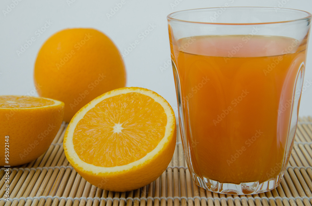 Orange Juice and Sliced Organic Orange On Bamboo Mat. Orange Juice and Sliced Organic Orange On Bamboo Mat.