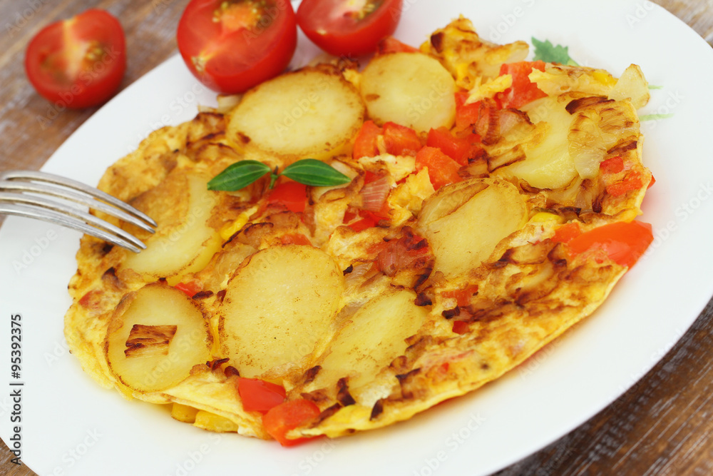 Omelette with potatoes, onions, red pepper and sweetcorn on white plate, closeup
Omelette with potatoes, onions, red pepper and sweetcorn on white plate, closeup