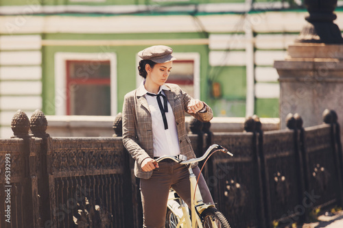 Young woman at vintage bicycle british style photo