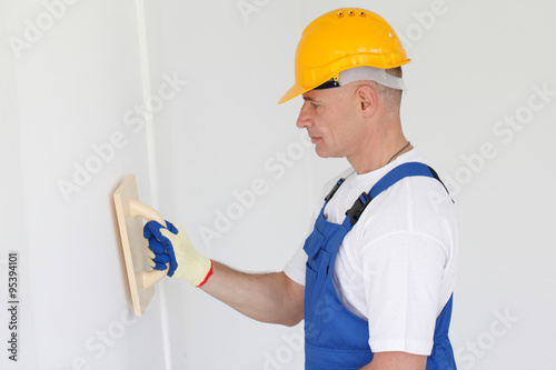 Workman polishing wall