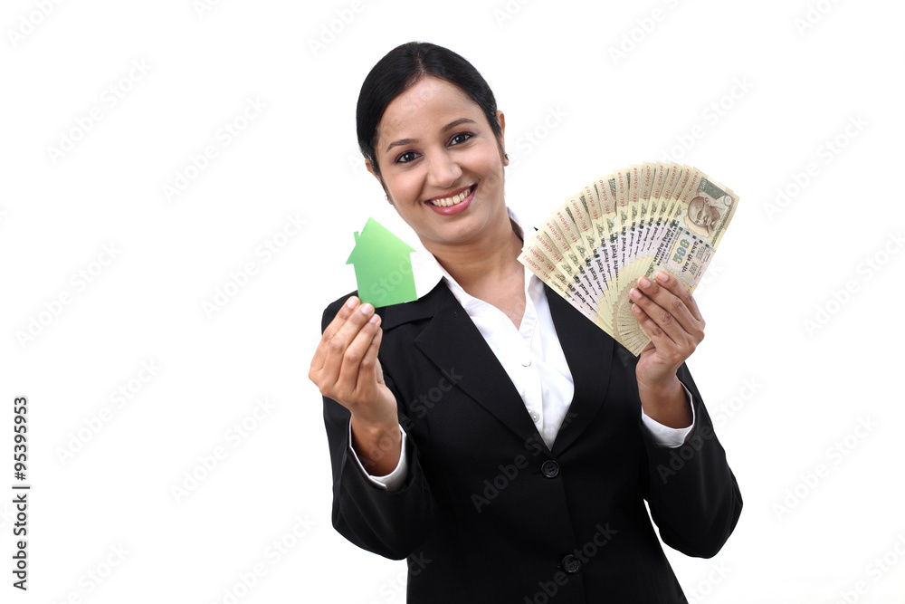 Young business woman with house model and Indian rupee notes in Young business woman with house model and Indian rupee notes in