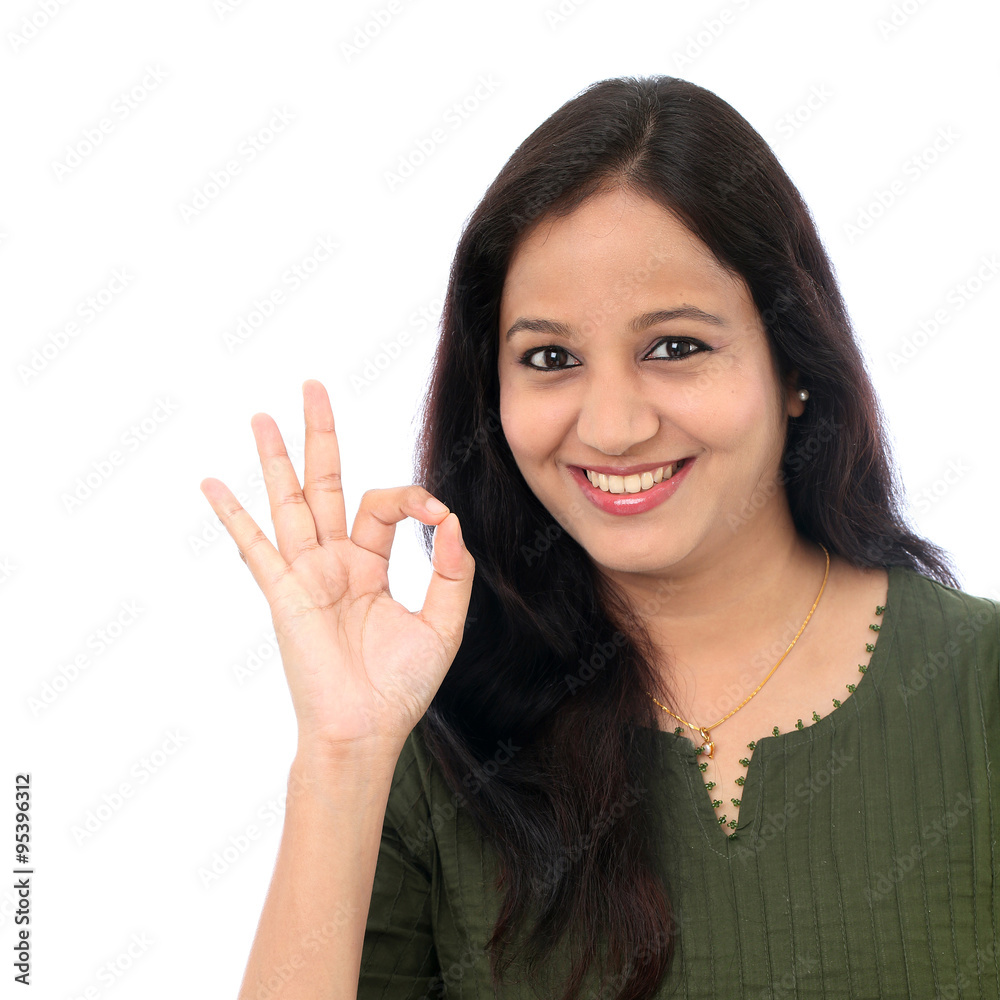 Young woman showing OK sign against white background Young woman showing OK sign against white background
