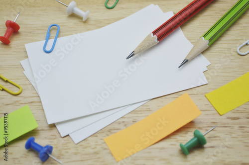 Namecard, pencil, clip and sticky notes on table