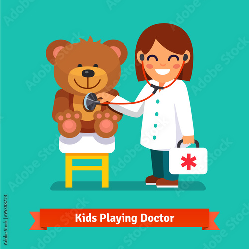 Small girl playing a doctor with teddy bear toy