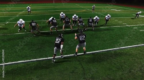 A football player gets tackled at the beginning of a play, view from above
