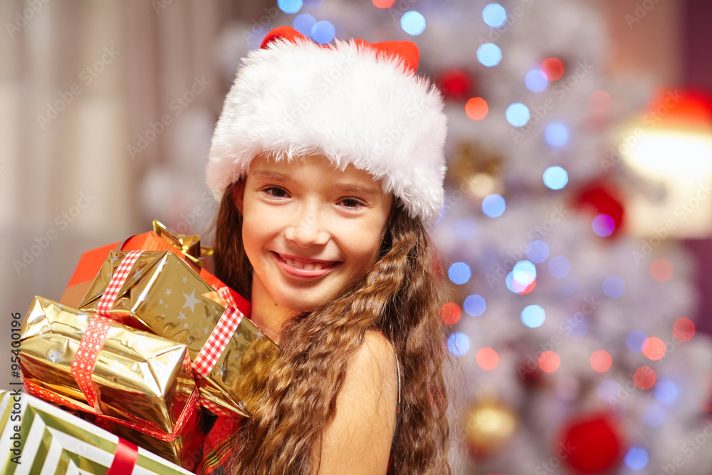 Young girl smiling with presents in fron of christmas tree Young girl smiling with presents in fron of christmas tree