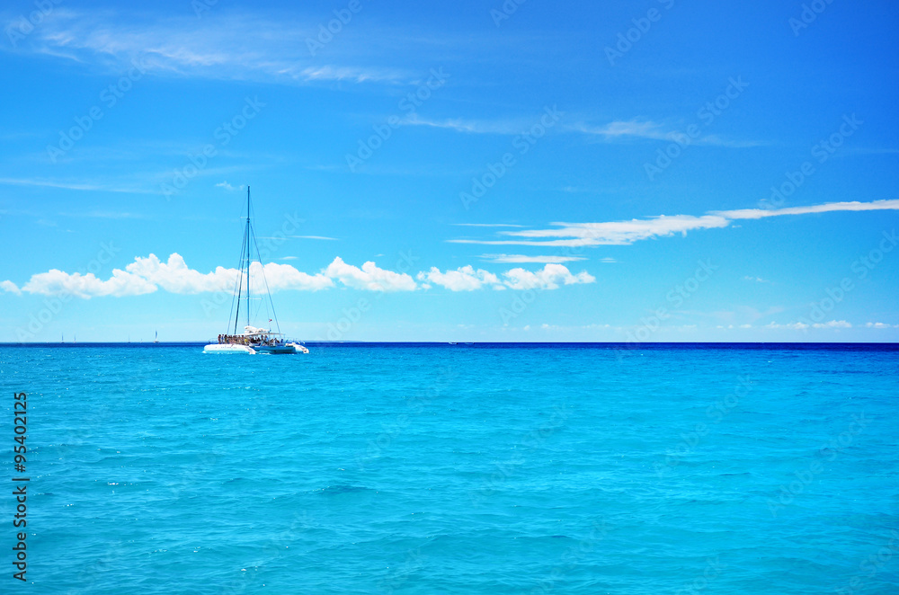 Sailing party catamaran in the blue carribean sea and cloudscape