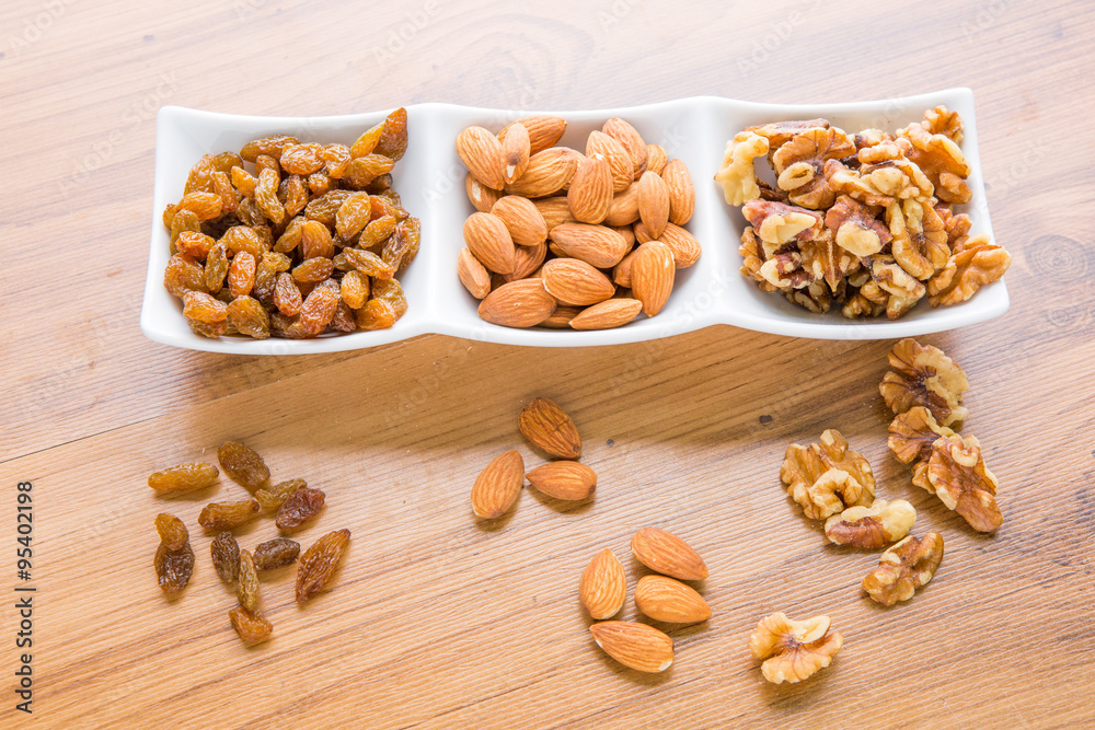 Mixed delicacies, walnut, currant, almond on wooden worktop Mixed delicacies, walnut, currant, almond on wooden worktop
