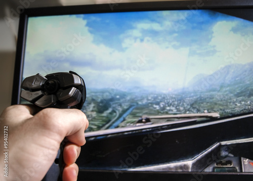 Hand on joystick, playing flight simulator photo