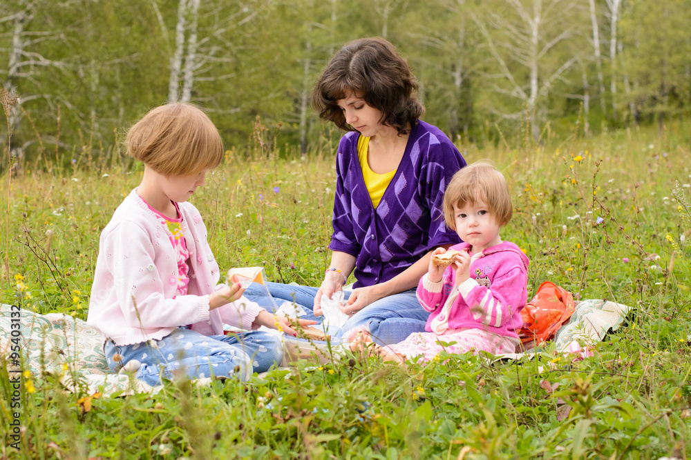 Mother with two daughters on a picnic Mother with two daughters on a picnic