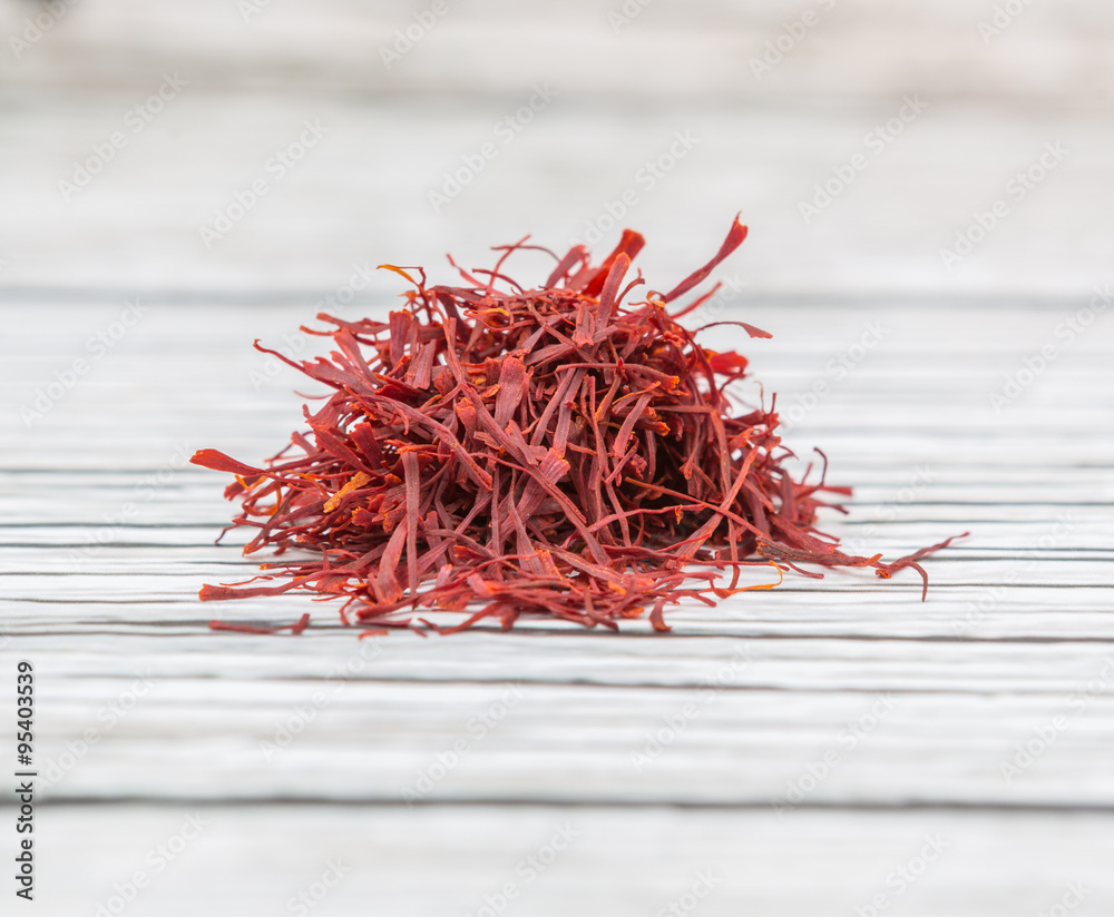 Naklejka premium Dried saffron spices over wooden background