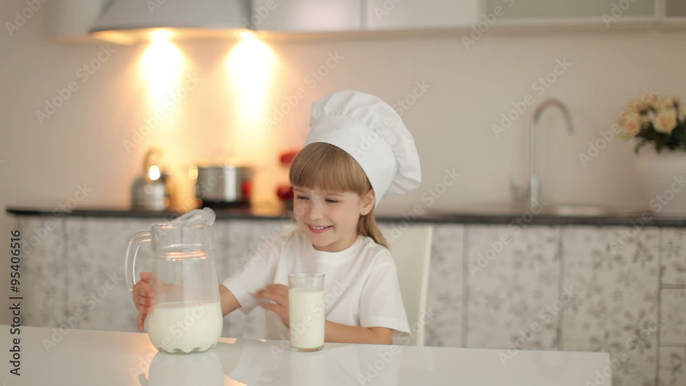 Little girl sitting in kitchen and she going to drink milk Little girl sitting in kitchen and she going to drink milk