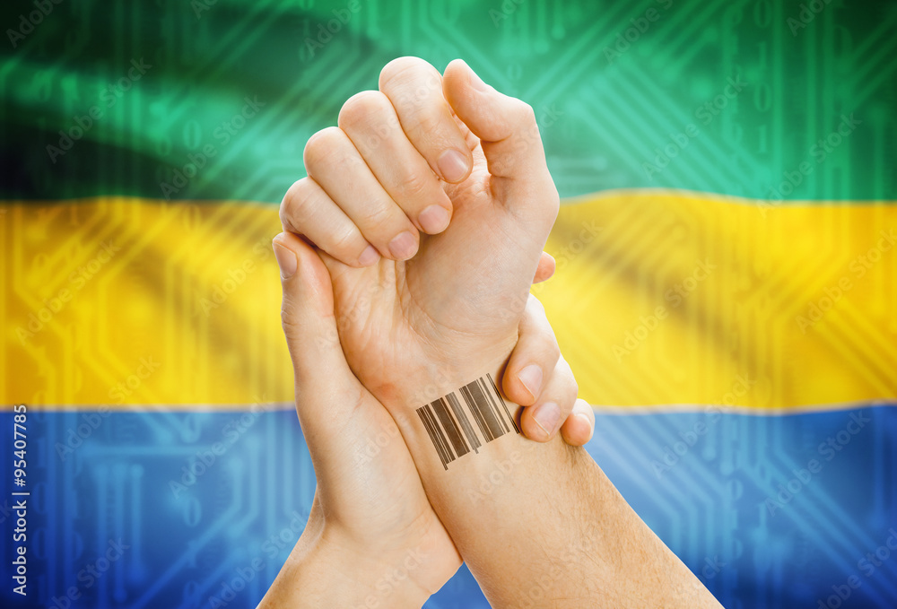 Barcode ID number on wrist and national flag on background - Gabon