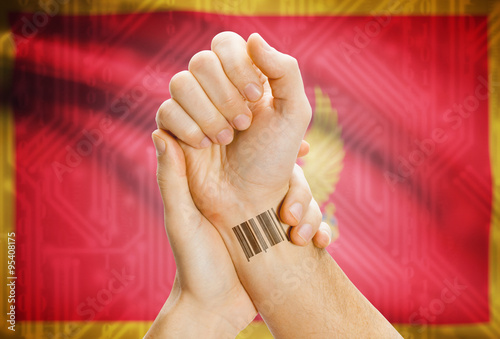 Barcode ID number on wrist and national flag on background - Montenegro