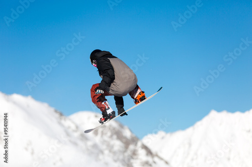 Snowboarder jumping in snow park