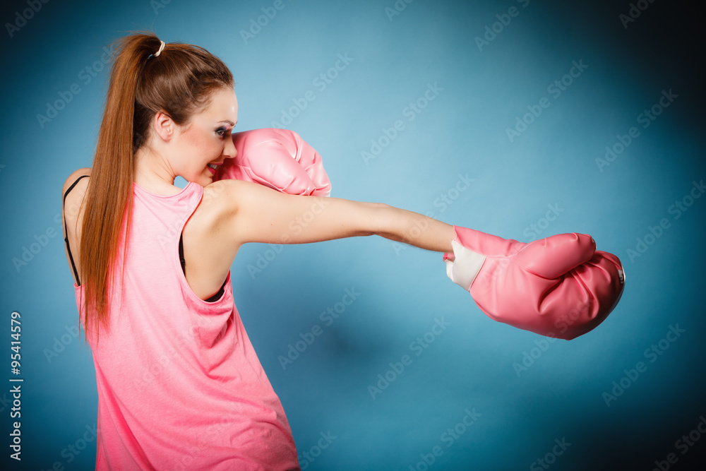 Female boxer wearing big fun pink gloves playing sports