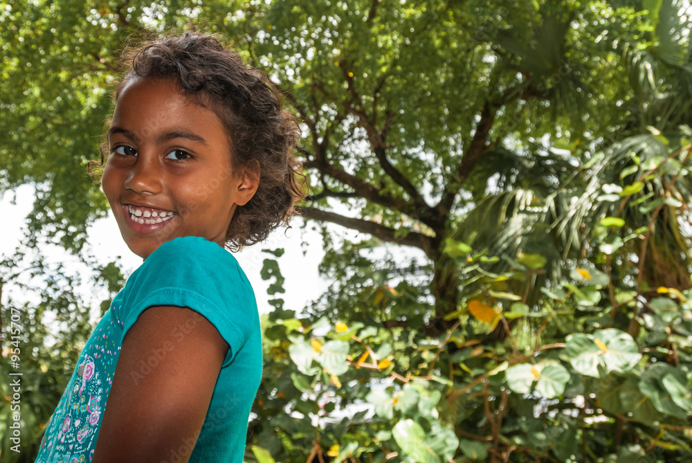 Beautiful young female girl with curly hair wearing a turquoise t-shirt. Portrait of happy female child in front of green background, pefect for family blogs and magazines Beautiful young female girl with curly hair wearing a turquoise t-shirt. Portrait of happy female child in front of green background, pefect for family blogs and magazines