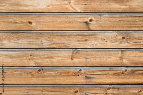 Larch wooden planks on the building facade covered with preventive impregnation