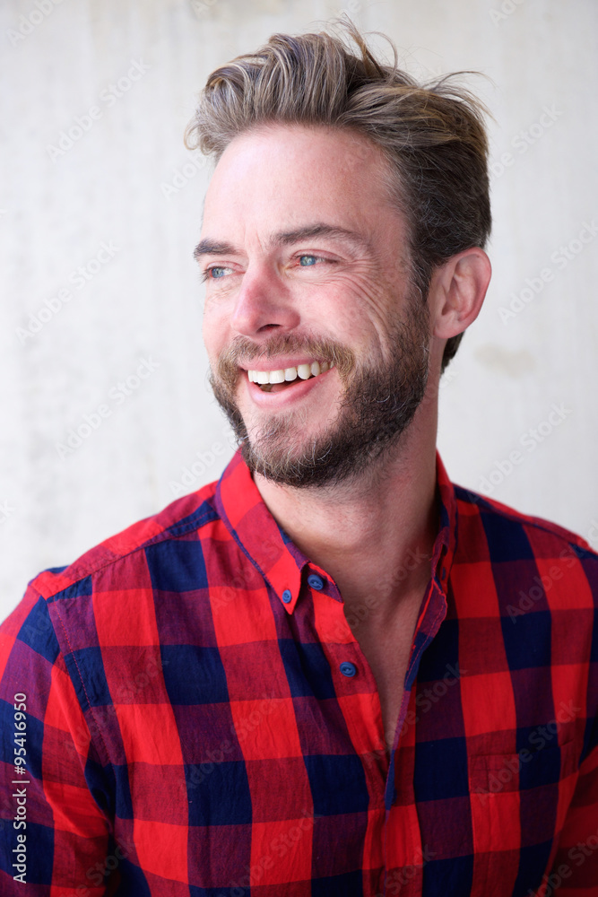 Handsome man with beard smiling and looking away Handsome man with beard smiling and looking away
