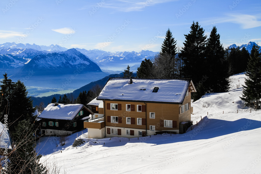 Panoramic skyline view of snow-capped chalets and mountains lake