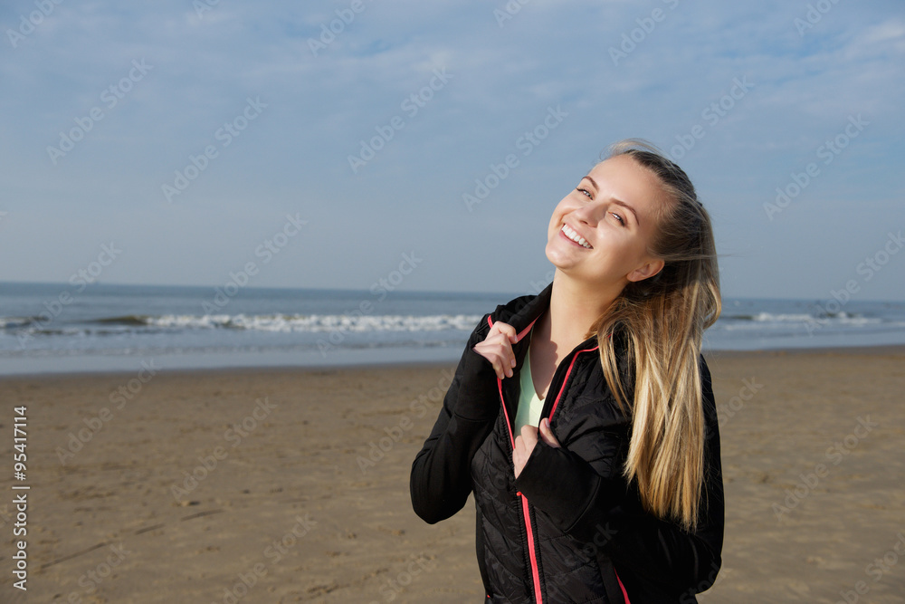 Smiling fitness girl standing outside on beach Smiling fitness girl standing outside on beach